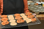 Woman holding Halloween biscuits on cake rack