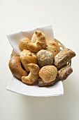 Bread rolls and croissants in bread basket (overhead view)