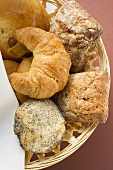 Bread rolls and croissants in bread basket (detail)