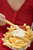 Woman dipping chip in mayonnaise