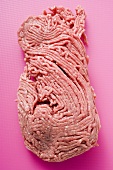 Frisches Hackfleisch auf pinkfarbenem Untergrund