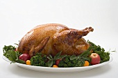 Roast turkey garnished with fruit and herbs