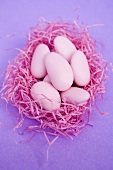 Pink sugared almonds in pink Easter grass