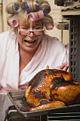 Despairing housewife with burnt turkey