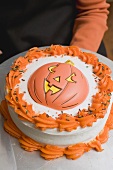 Hand holding Halloween cake on plate