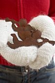 Hands in mittens holding two angels (Christmas decorations)