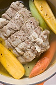 Boiled beef with soup vegetables in cocotte (close-up)