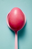 Red Easter egg on spoon (overhead view)