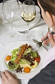 Woman eating salad in restaurant