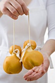 Woman holding two Provolone cheeses