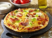 Tomato, mozzarella and ham pizza with basil