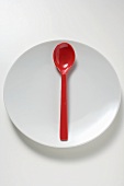 Red spoon on white plate
