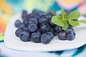 Blueberries with leaves on plate