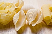 Various types of pasta on wooden background