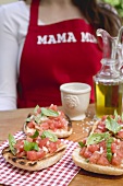 Bruschetta with tomato salsa, woman in background