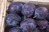 Fresh plums in woodchip basket