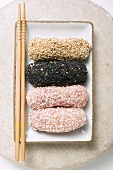 Dumplings coated in sesame seeds & coconut in dish (Japan)