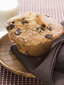 Chocolate chip muffin on wooden plate with napkin