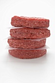 Raw burgers, in a pile