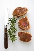 Pork fillet barded with bacon, rosemary, knife