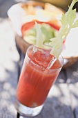 Tomato drink with celery and ice cubes