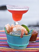 Shrimps with dip, cocktail in background