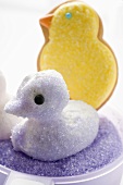 Meringue chick with purple sugar, Easter biscuit in background