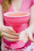 Woman holding a pink cocktail