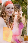 Zwei junge Frauen mit Eistee beim Gartenfest