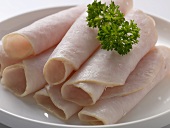 Several rolls of ham garnished with parsley