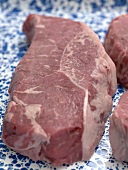 Raw beef steak on patterned plate