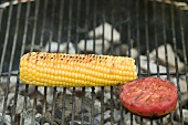 Cob of corn and tomato on a barbecue