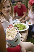 Young people with popcorn and salad at a garden party