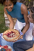 Frau serviert Blueberry Pie zum Picknick am 4th of July (USA)