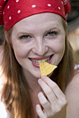 Woman nibbling a tortilla chip