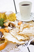 Fried pastries with icing sugar, baked dumplings & cup of punch