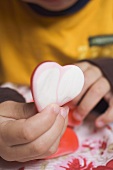 Child's hand holding sugar heart