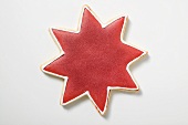Ein Sternplätzchen mit roter Glasur