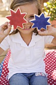 Small girl holding two star cookies (4th of July, USA)