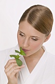 Woman smelling a sprig of fresh mint