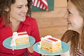 Women holding pieces of cake on plates (4th of July, USA)