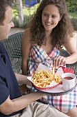 Couple sitting on terrace eating chips