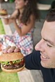 Couple eating hamburgers on terrace