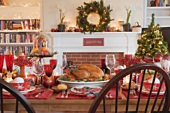 Christmas table with turkey in front of fireplace (USA)