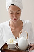 Woman holding tray with tea and white flower