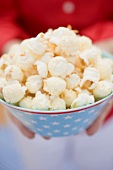 Woman holding popcorn in bowl with stars (4th of July, USA)