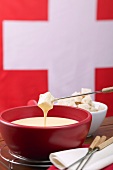 Käsefondue vor Schweizer Flagge
