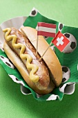 Hot dog with mustard & flags on napkin with football motifs