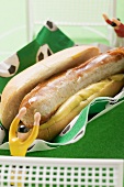 Hot dog with mustard and toy footballers