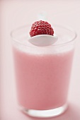 Raspberry shake with spoon and fresh raspberry